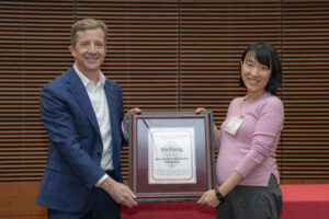 a man and a woman hold a framed certificate