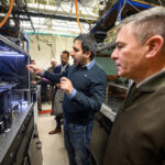 a group of people walks through a room with equipment