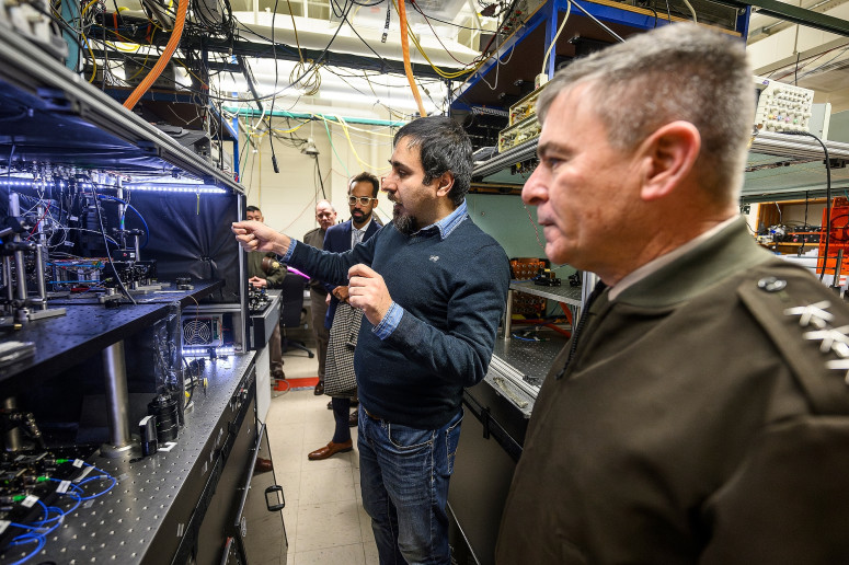 a group of people walks through a room with equipment