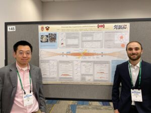 two people stand in front of their scientific poster